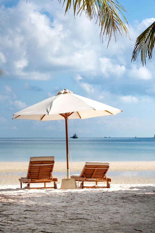 Armchairs Beside Umbrella Near Seashore